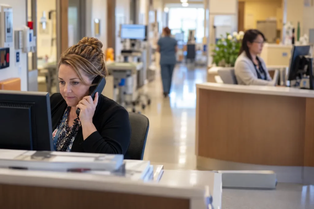 A unit clerk at a hospital ward desk